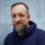 uśmiechnięty mężczyzna w średnim wieku z brodą w okularach